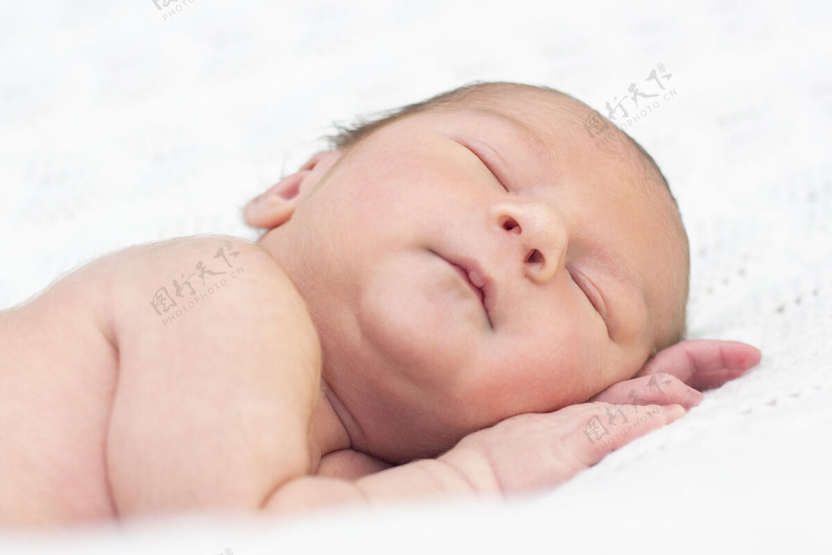 休息新生婴儿睡觉和睡觉微笑接近美丽的熟睡婴儿的画像毯子新生儿夜晚