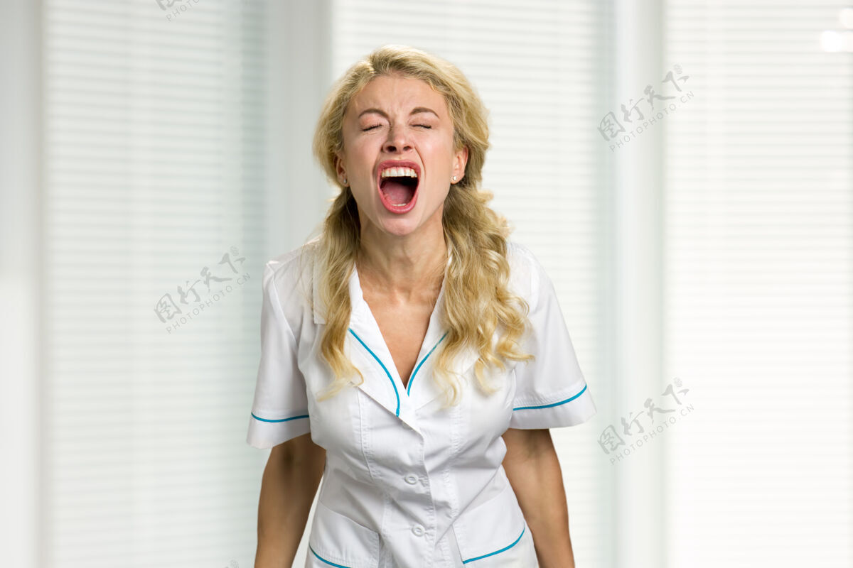 人年轻护士绝望地尖叫着压力很大的年轻漂亮女医生沮丧地闭着眼睛大声尖叫着女性诊所职业