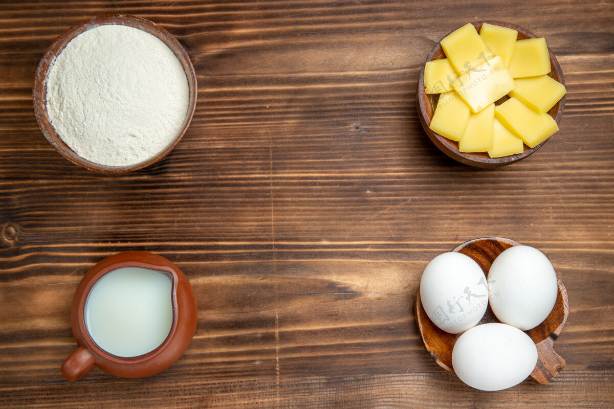 牛奶顶视图全生鸡蛋配乳酪粉和牛奶放在棕色木桌上产品蛋面团糕点顶部烹饪鸡蛋