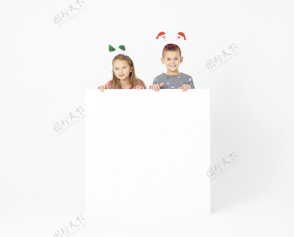 女孩带着空白横幅的可爱孩子们庆祝空白黑板