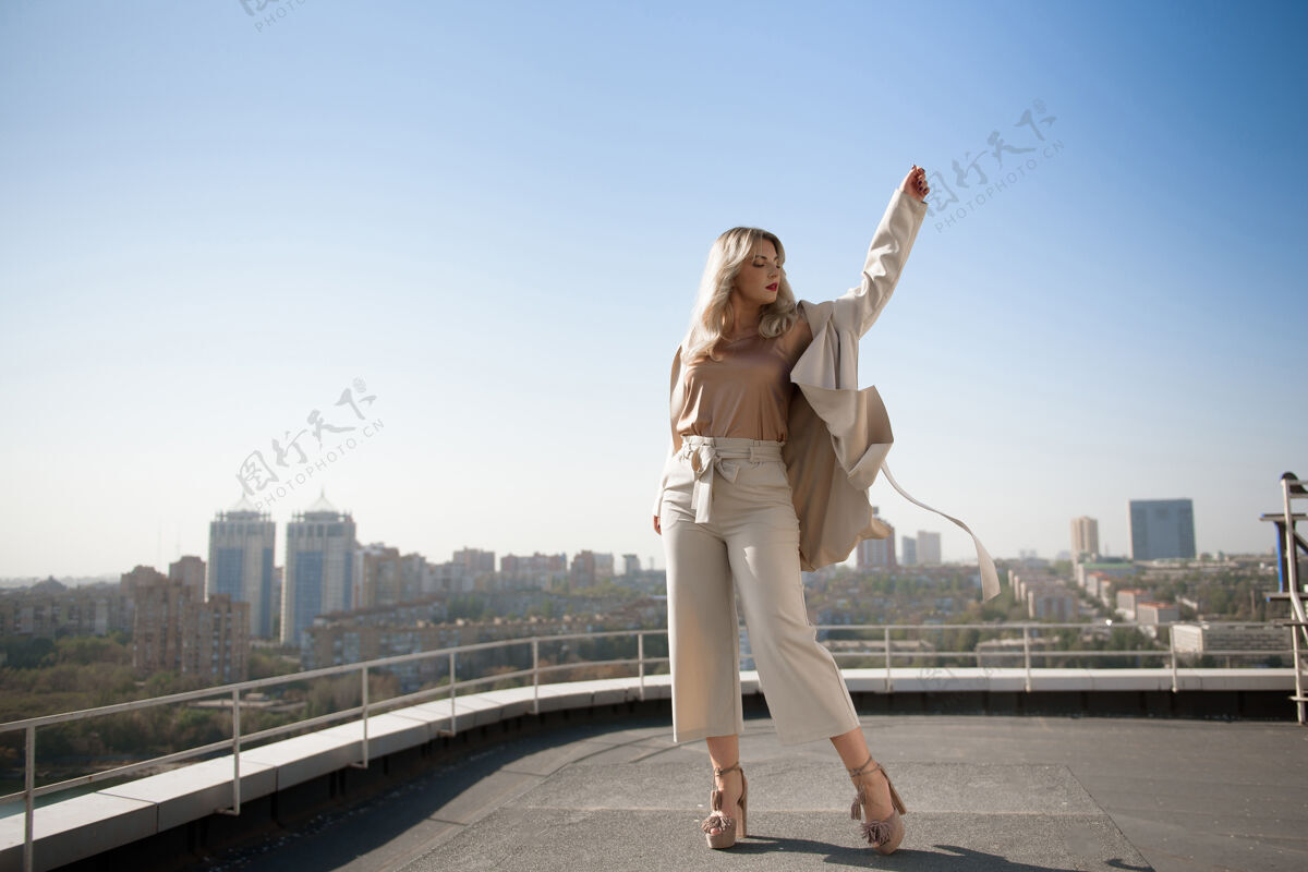 城市迷人的年轻女子站在酒店的屋顶上 俯瞰着一个小镇女人时尚风