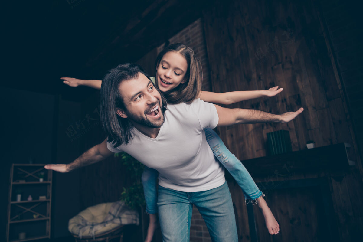 休闲照片中的小搞笑精力充沛的女孩兴奋帅气的爸爸抱着女儿玩游戏好心情消磨空闲时间飞机兴奋飞行