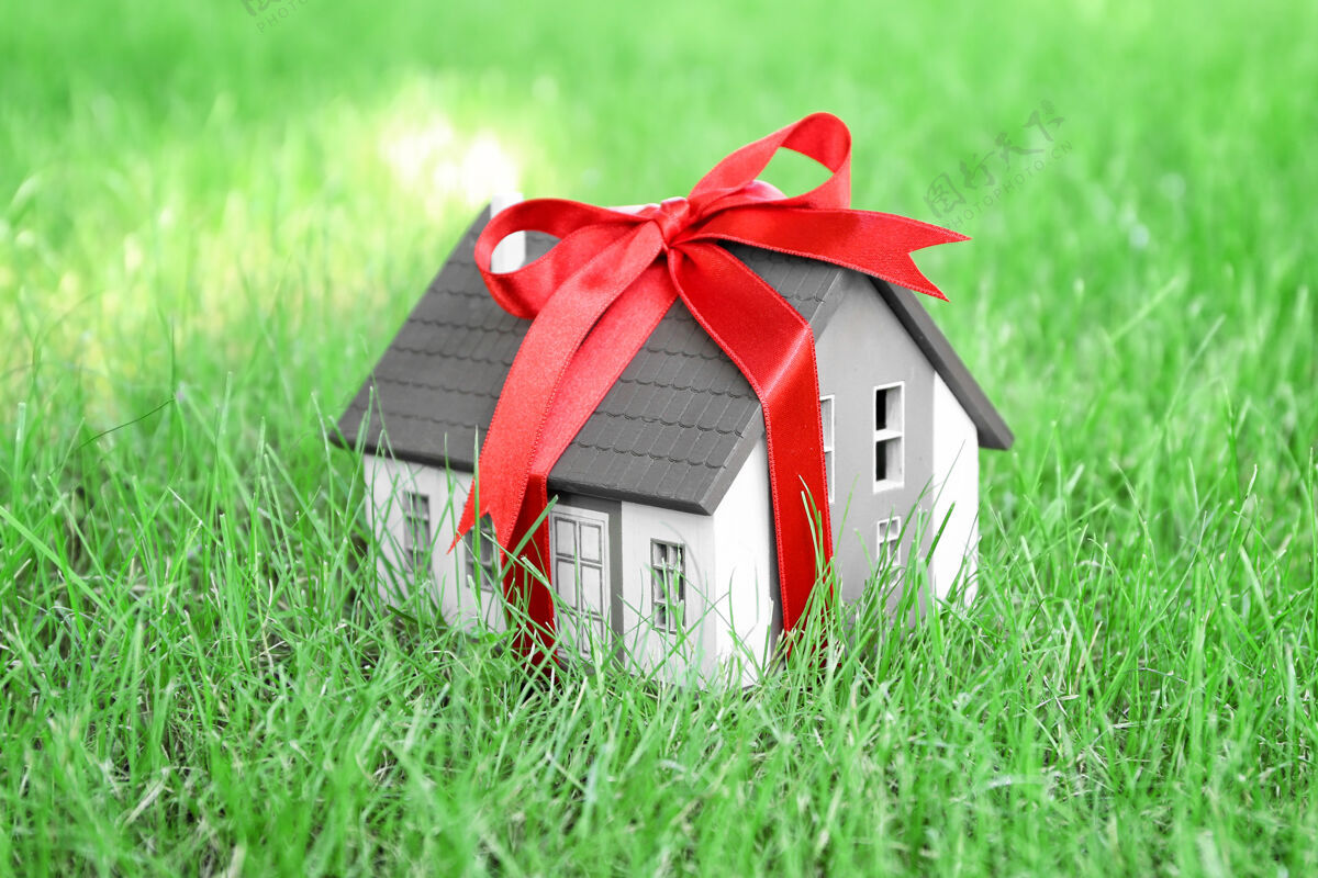 房地产绿色草坪上有缎带的房子模型按揭概念钱礼物物业