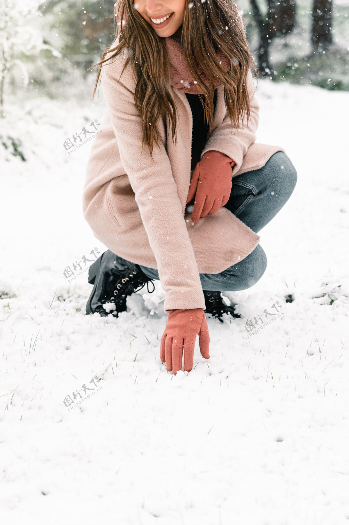 温暖的衣服一个穿着暖和衣服的匿名女人 在冬天摸着雪享受周末寒冷森林下雪