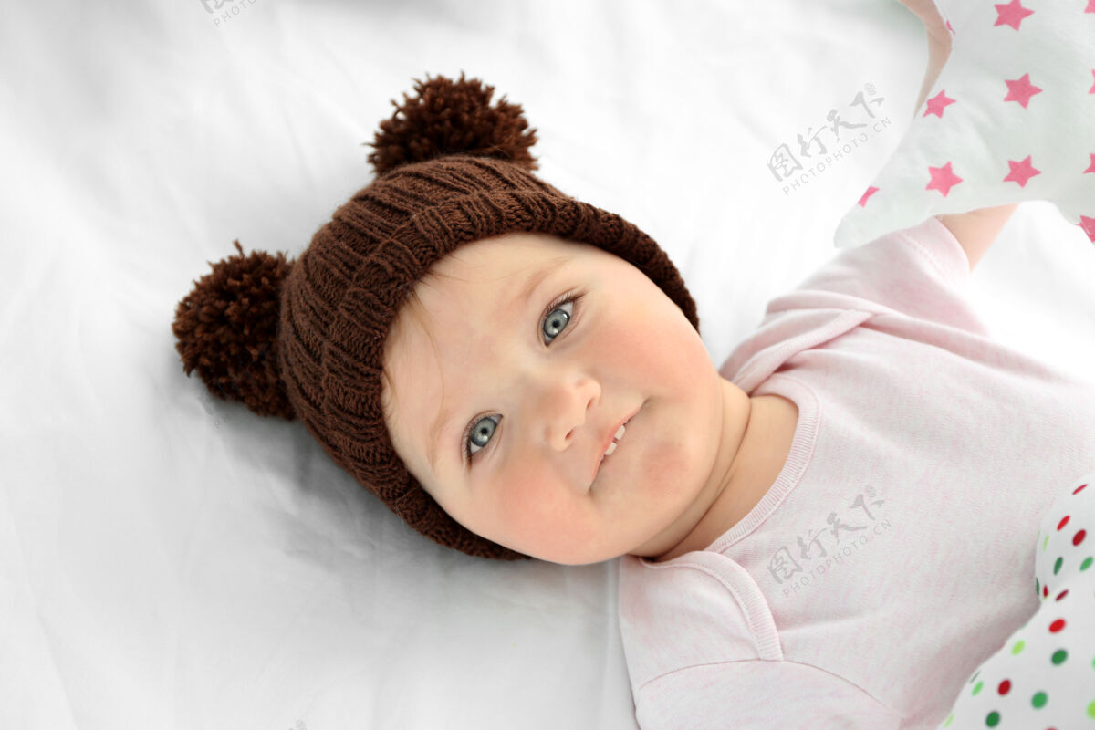 帽子可爱的女婴戴着帽子 躺在白床单上睡眠健康可爱