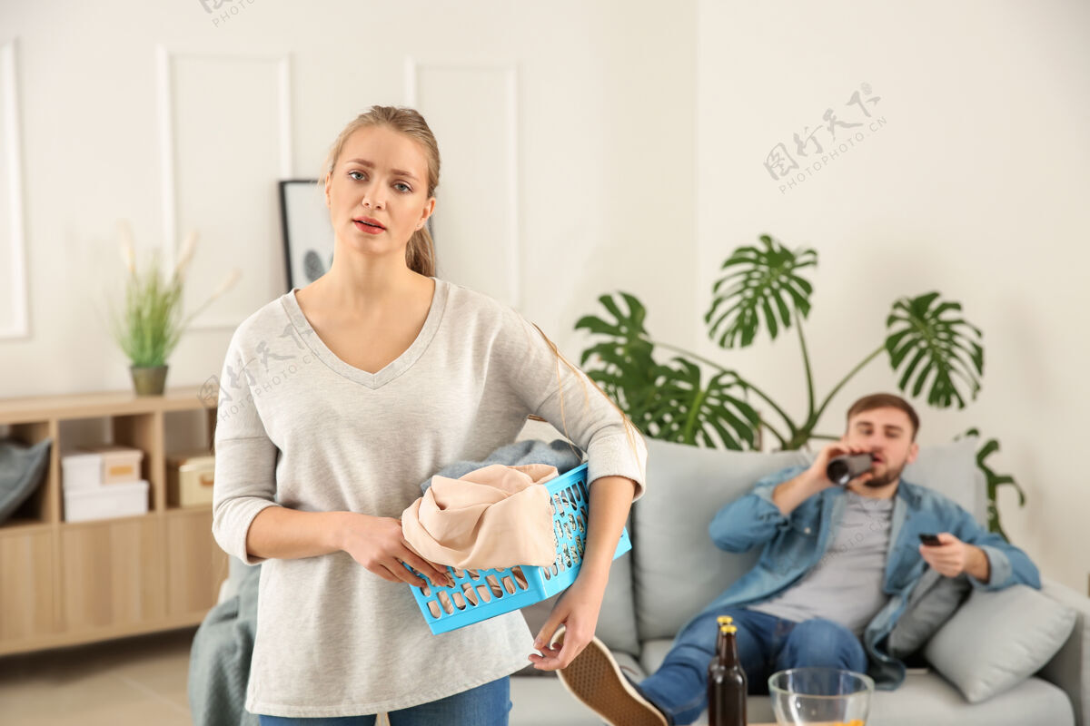 沙发伤心的主妇洗衣服 懒丈夫躺在沙发上妻子家务工作