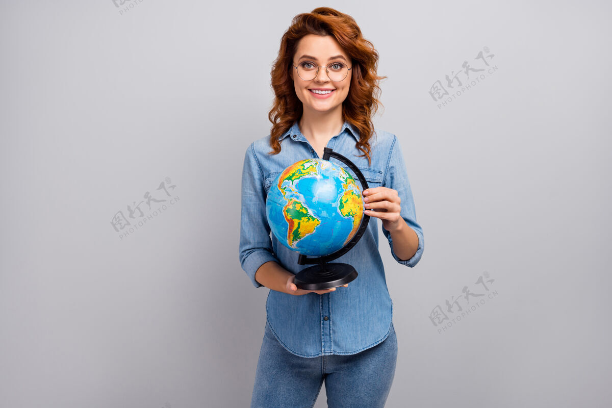 工作正面开朗的女性肖像高中地理教授手持地球仪欣赏有趣的生态世界自然讲座穿着好看的服装隔着灰色的墙情感女人科学
