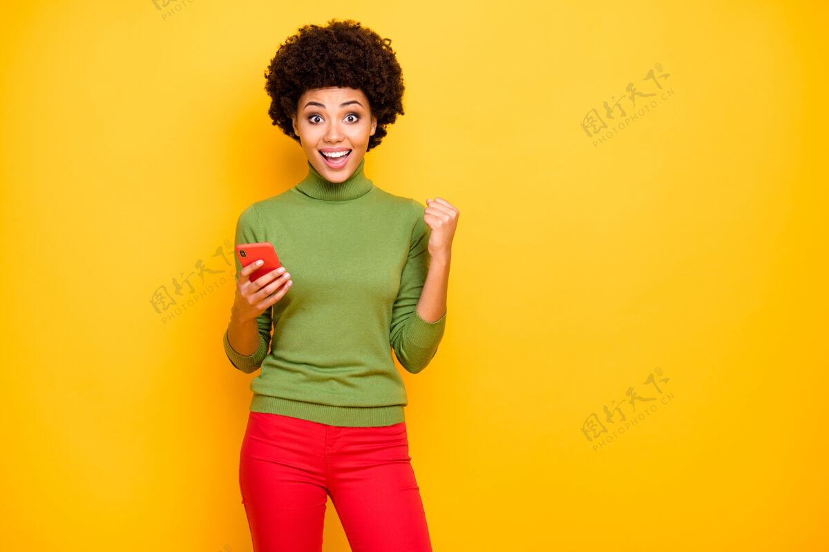 休闲开朗积极可爱可爱甜美女人的肖像 穿着红色裤子 在脸上牙牙学语地表达积极的情绪惊奇手机休闲