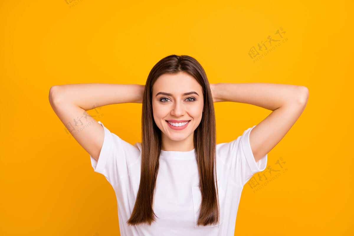 爱特写照片相当冷静女士好心情打盹思考手臂脑后高兴的牙齿微笑穿休闲白色t恤隔离生动的黄色墙壁放松女性手