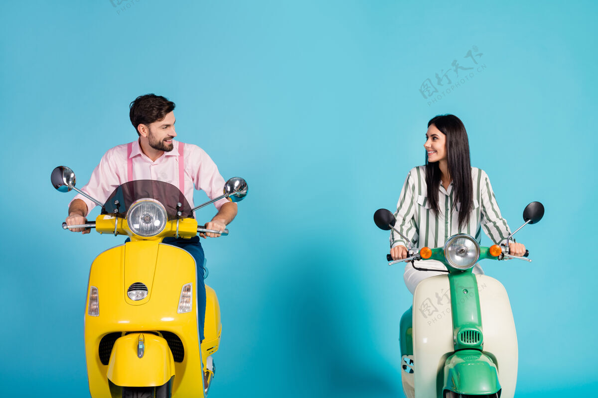 车辆积极向上开朗可爱的妻子丈夫骑自行车的人驾驶直升机的样子喜欢摩托车的方式旅行穿条纹粉色的正装衬衫隔离在蓝色的墙上在一起快乐道路