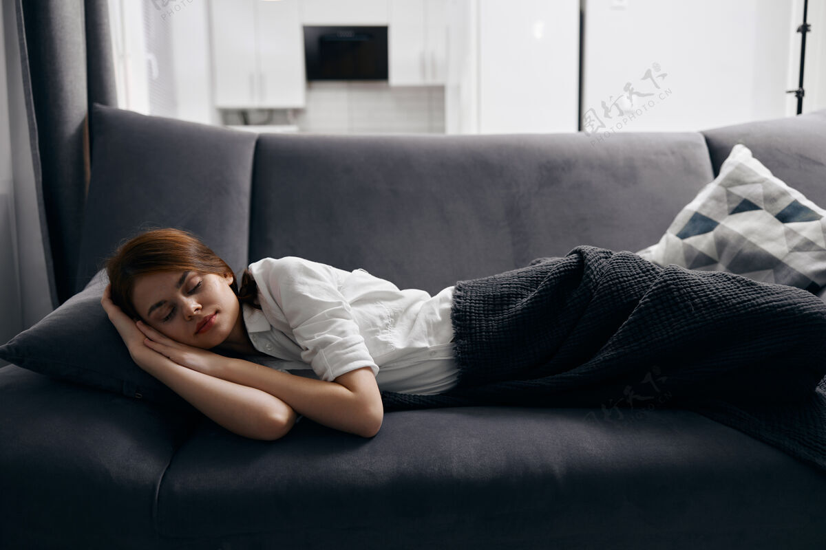 女性闭着眼睛躺在沙发上休息的女人 特写镜头生活方式成人休息
