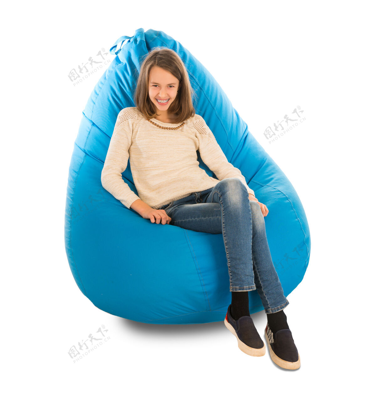 坐着年轻可爱的女孩微笑着坐在白色的蓝色豆包上家具沙发室内