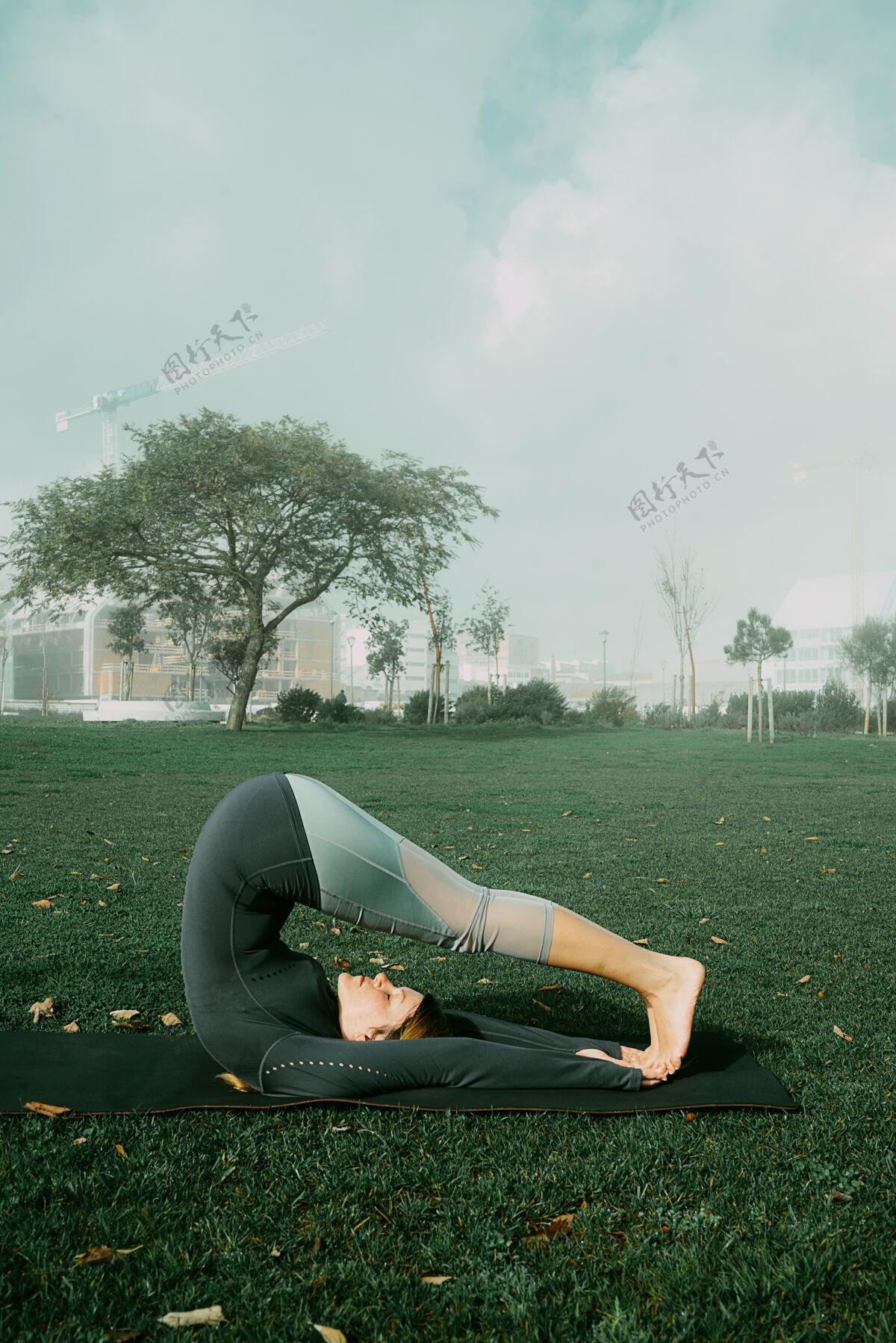 美丽在公园里用瑜伽垫做瑜伽 伸展运动 锻炼的年轻女子天生的瑜伽初学者姿势医疗理念健康姿势活跃