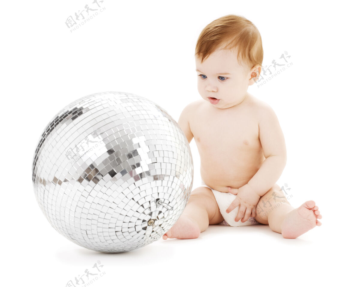 年轻可爱的男婴和大迪斯科球超过白色皮肤快乐玩耍