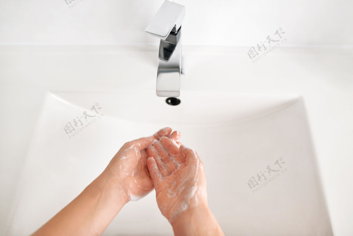 冠状病毒妇女在家中洗手间的白色洗手盆洗手的特写照片 顶视图女性水槽人
