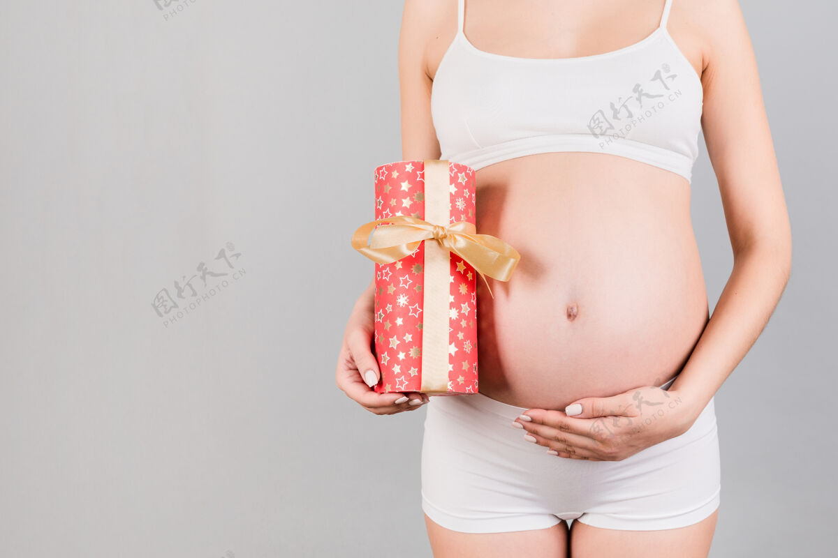 盒子穿着白色内衣的孕妇手里拿着礼盒人类腹部女人