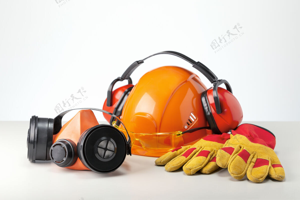 工作服个人防护设备 呼吸系统 头盔 耳机 眼镜和手套在灰色表面上工作安全施工人员防护