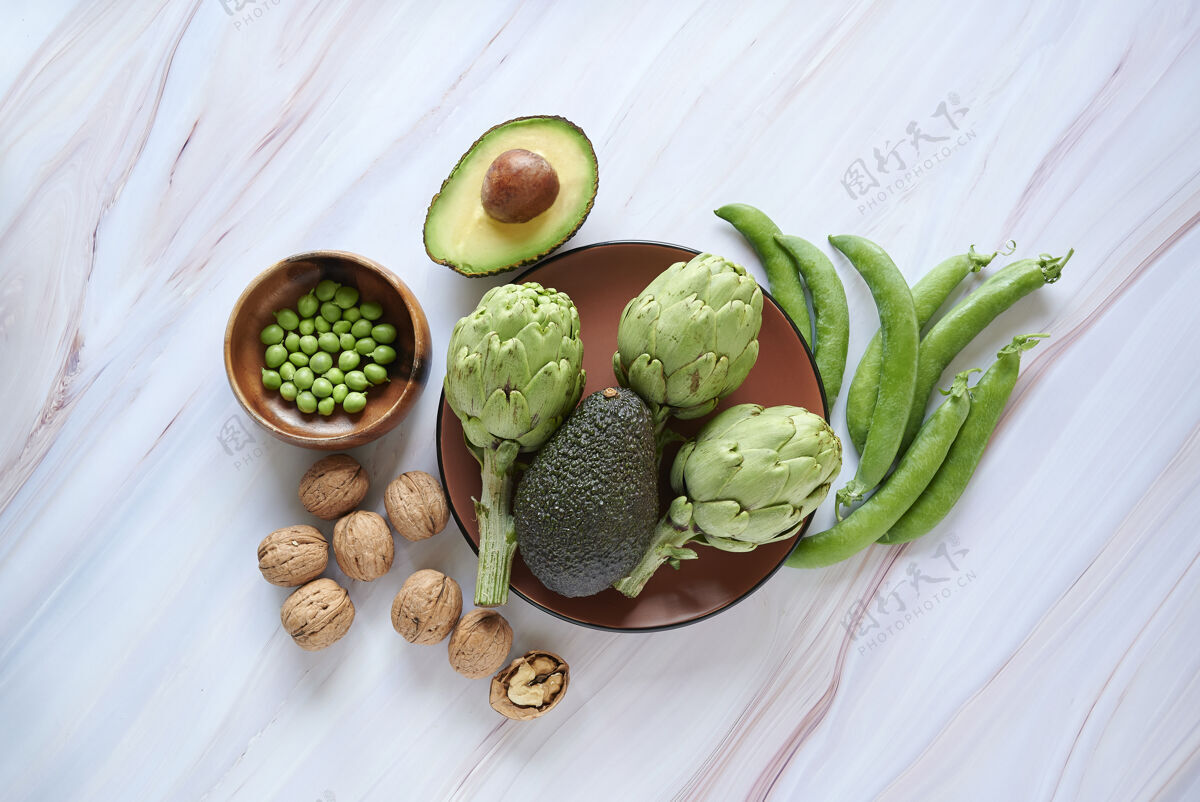 饮食洋蓟 鳄梨 核桃和绿豆以大理石为背景 健康健康的生活理念健康生活平衡豆荚