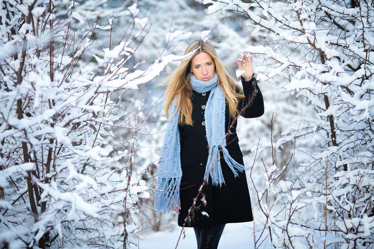 风美丽的金发少女漫步在冬日的森林里毛衣快乐公园