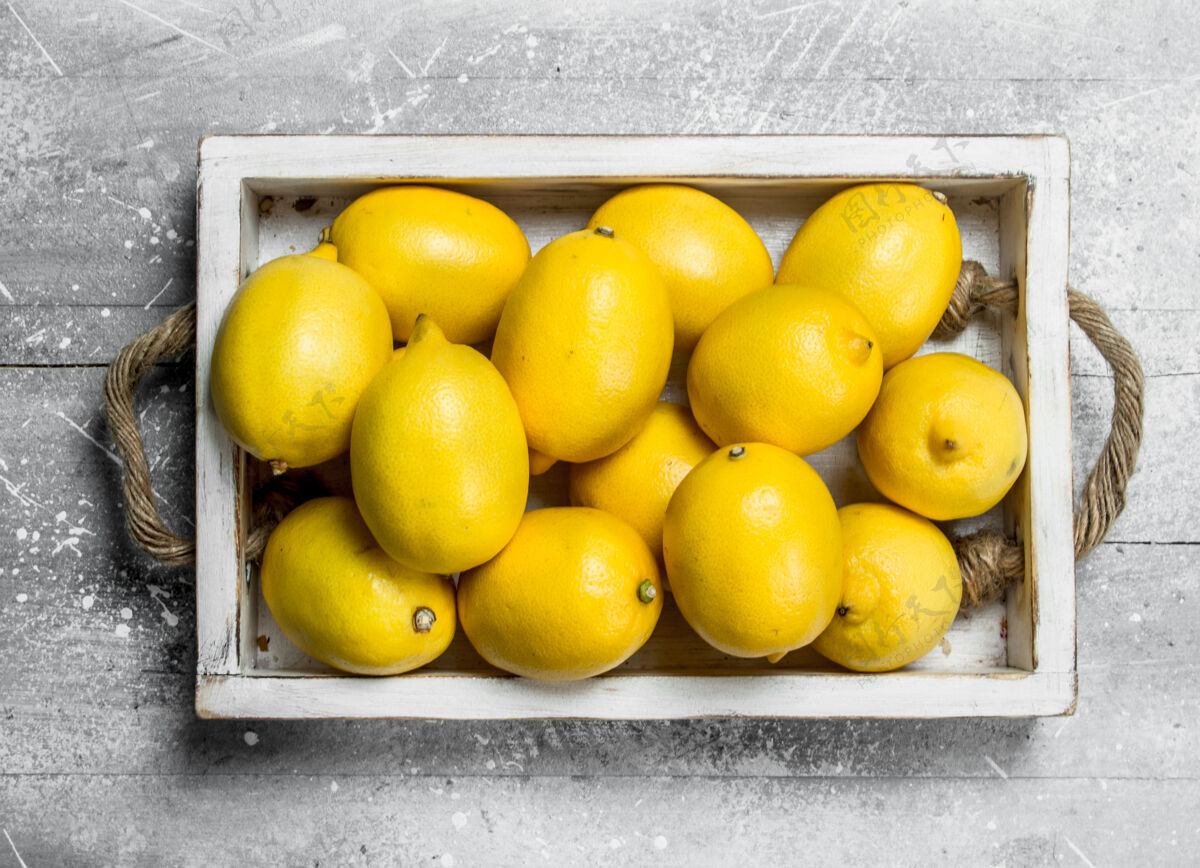成熟新鲜柠檬托盘.on一张白色的乡村桌子水果光泽顶部