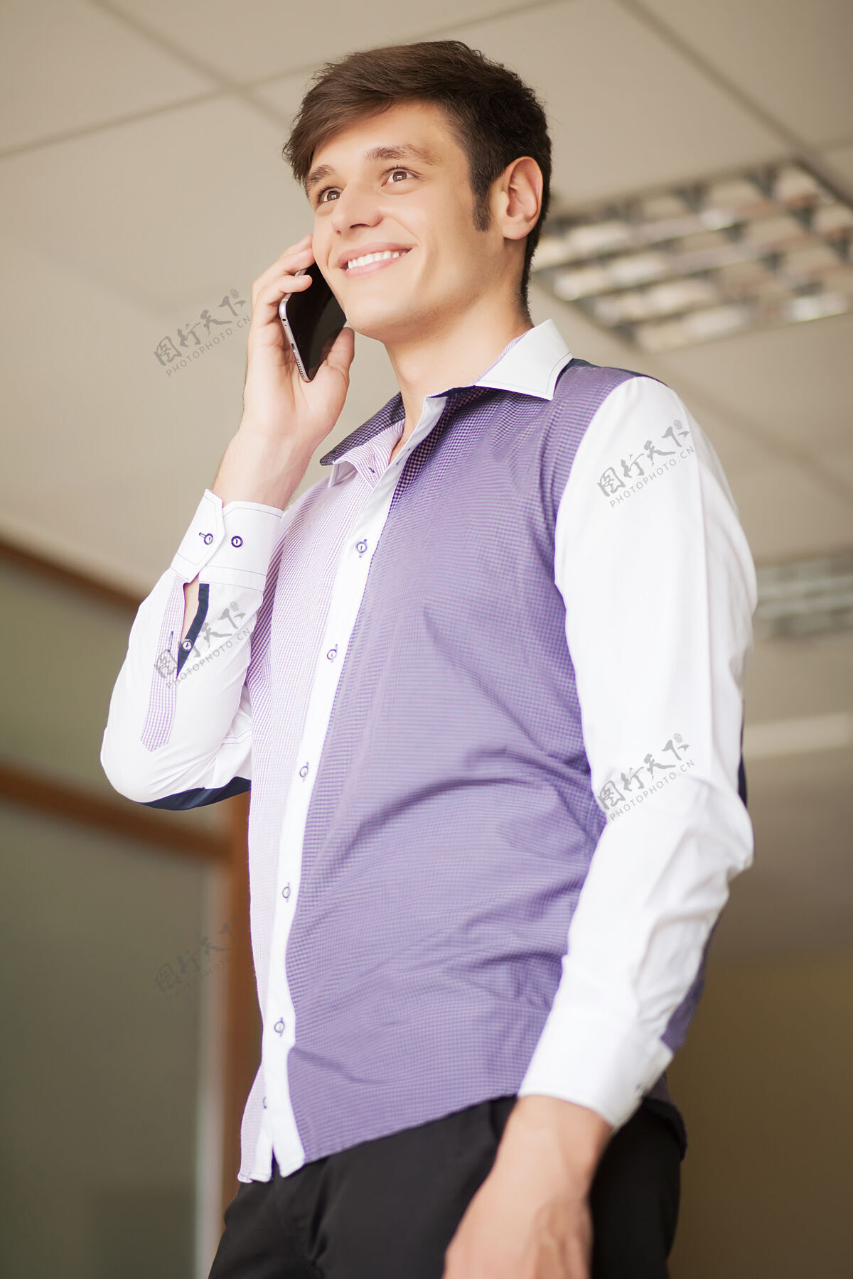 应用程序快乐的年轻商人在办公室里呼唤智能手机电话正式年轻人