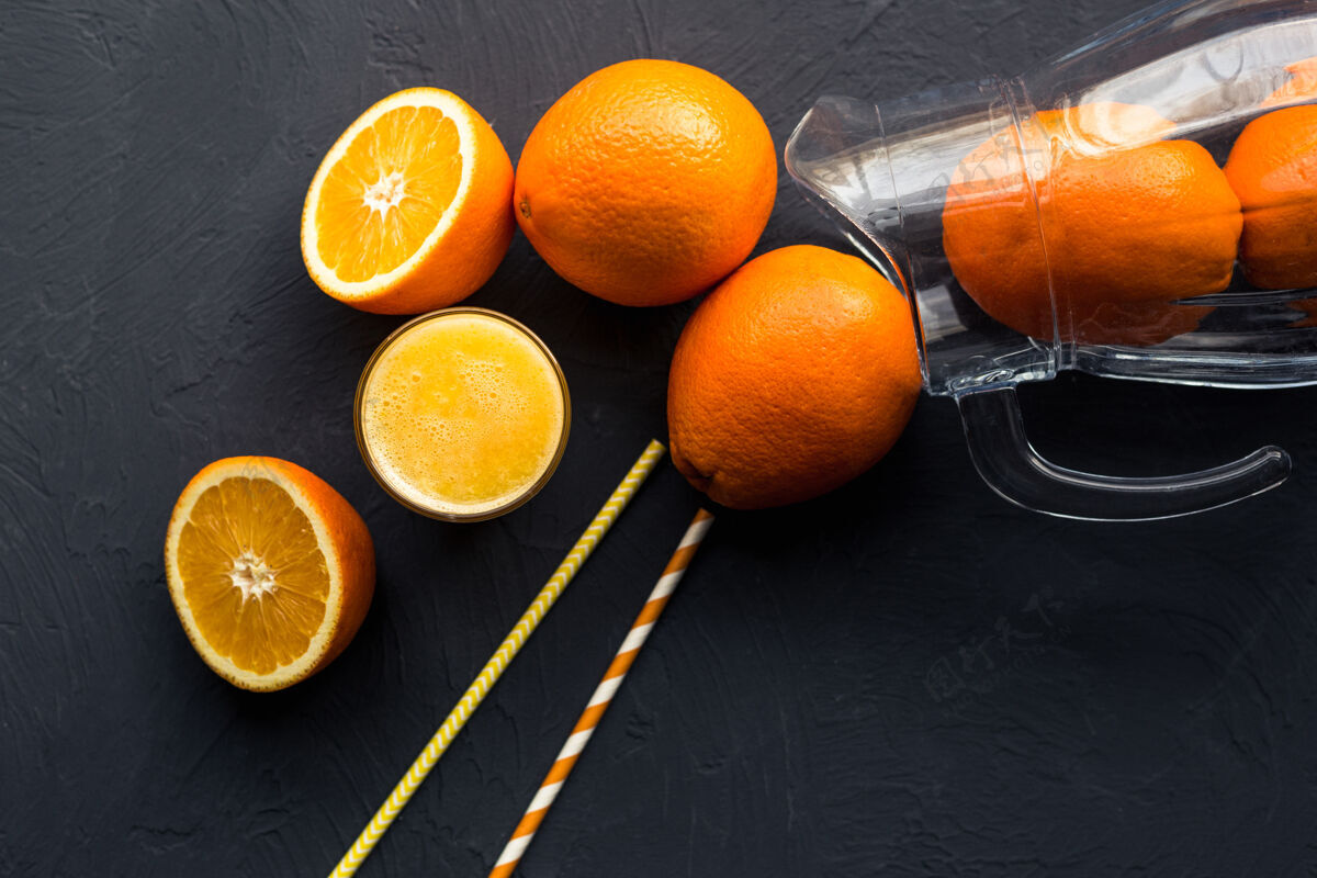 挤压一张黑桌子上放着新鲜的橙汁和橙子生的饮料柑橘