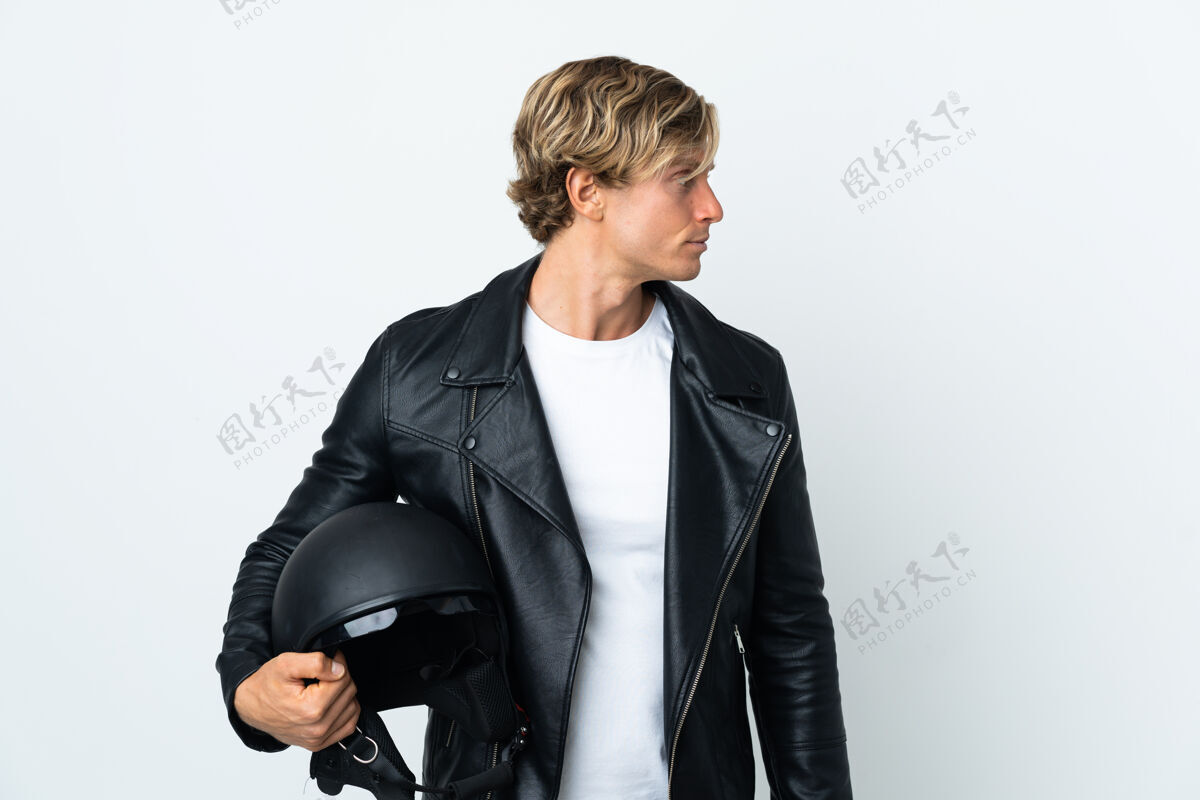 肖像一个拿着摩托车头盔的英国人朝旁边看美国人皮革头盔