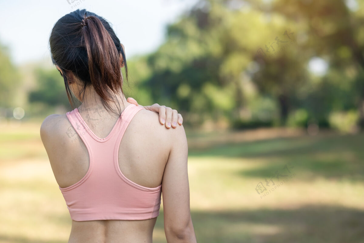 慢跑年轻的健身女抱着她运动受伤的肩膀 运动过程中肌肉疼痛培训.亚洲女跑步者夏天在户外运动后身体有问题物理私人教练健康