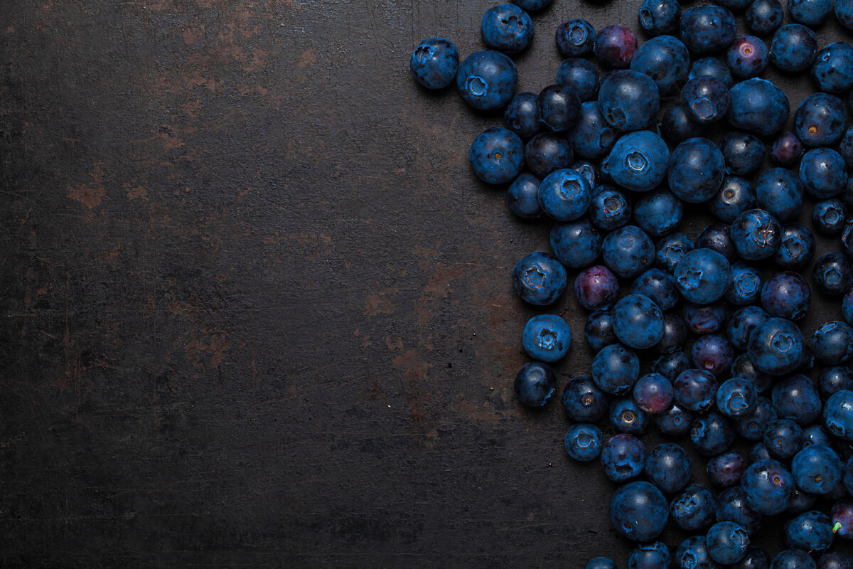 背景俯瞰躺在古老乡村背景上的一堆蓝莓新鲜蓝色饮食