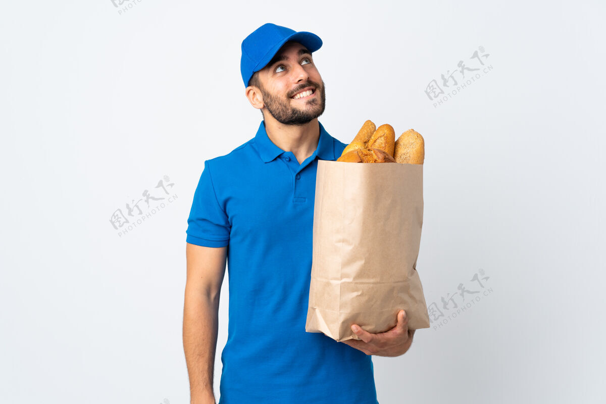 面包送货员手里拿着一袋面包 隔着白色的面纱抬头微笑着工人信心幸运