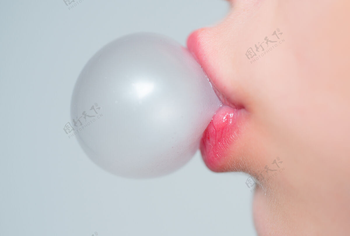 泡泡女性嘴唇吹粉红泡泡口香糖特写一张有着粉红色嘴唇和泡泡糖的女人脸闪亮嘴巴色情