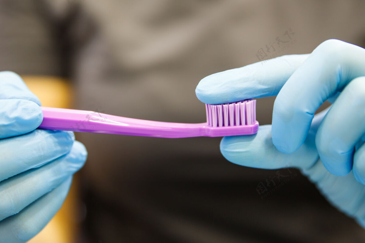 牙齿女牙医或口腔医生手持并展示紫色牙刷的特写镜头 显示刷毛刚度.齿卫生手口腔工具