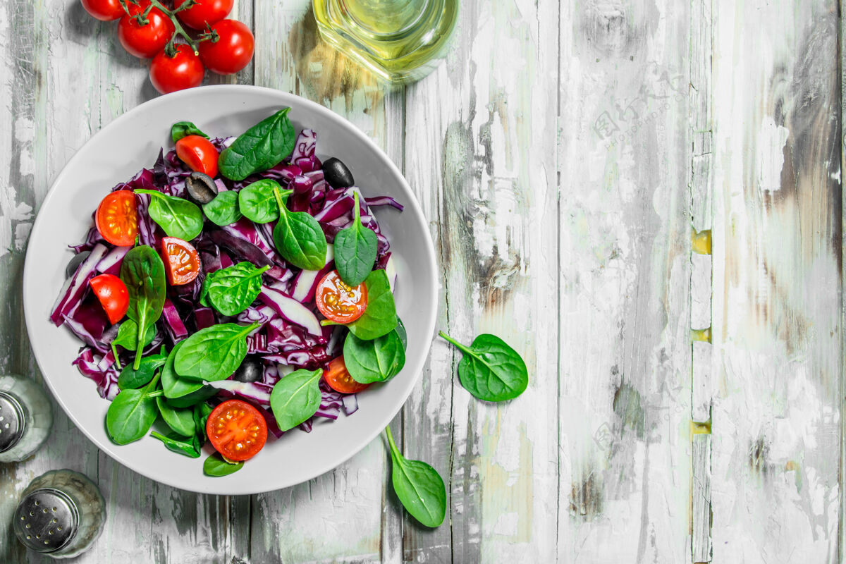 素食蔬菜沙拉红色卷心菜 番茄和菠菜沙拉加橄榄油维生素健康盘子
