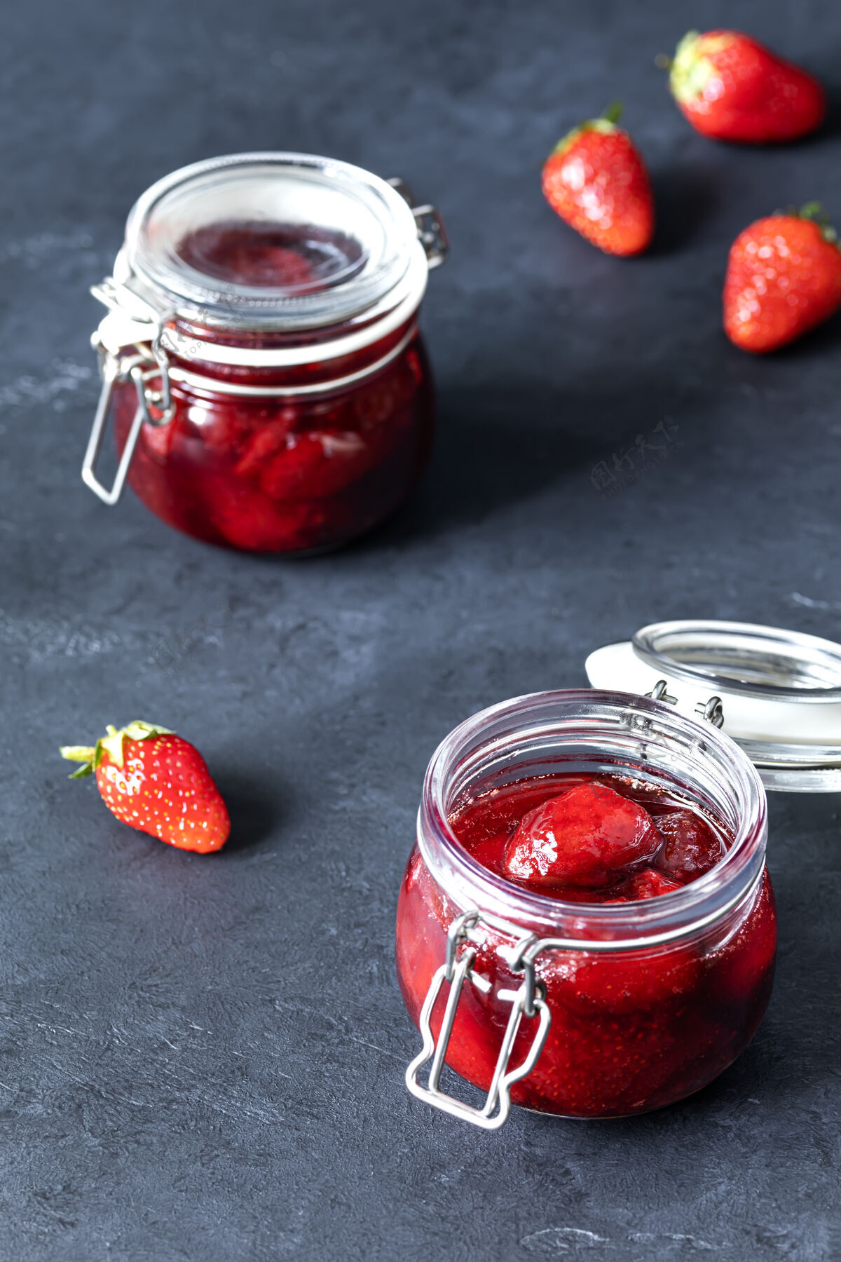 自封一罐罐自制草莓果酱和成熟的草莓放在黑暗的表面上甜食罐头浆果