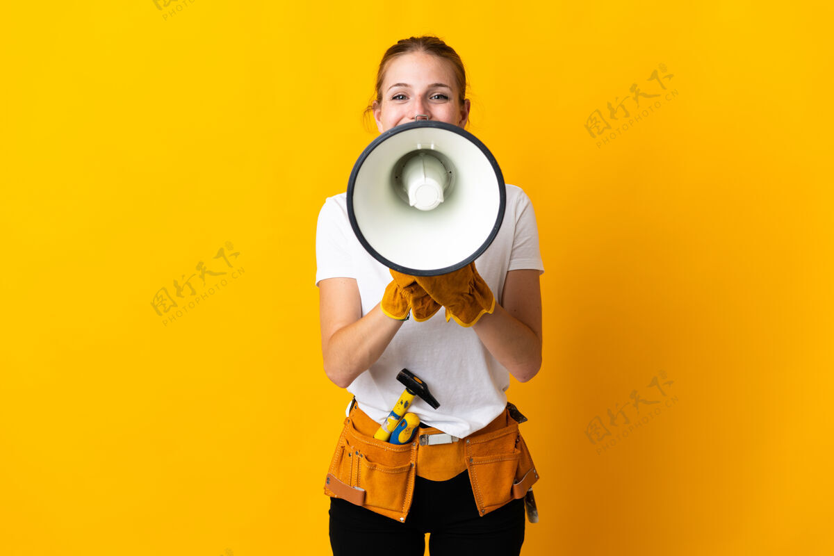 技能被隔离在黄色背景下的年轻电工妇女通过扩音器大声喊叫木匠表达扩音器