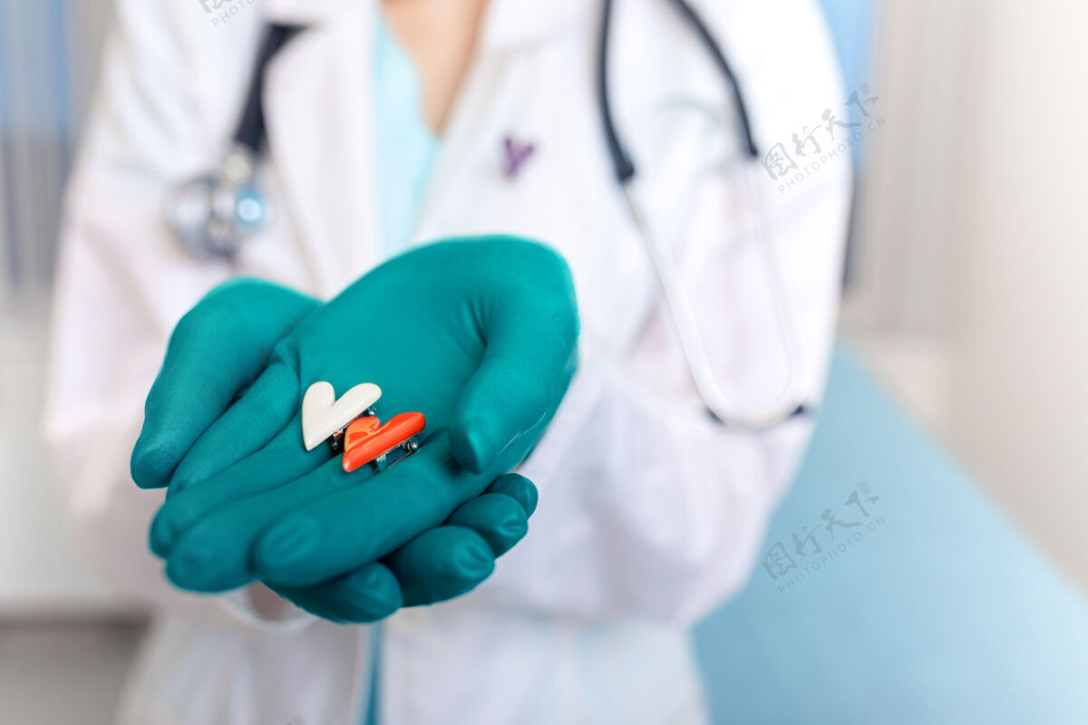 形状医生手里拿着一个心脏捐献和植入医生救命的标志 医生手里拿着一个救命手套的空间复印件医生手特写