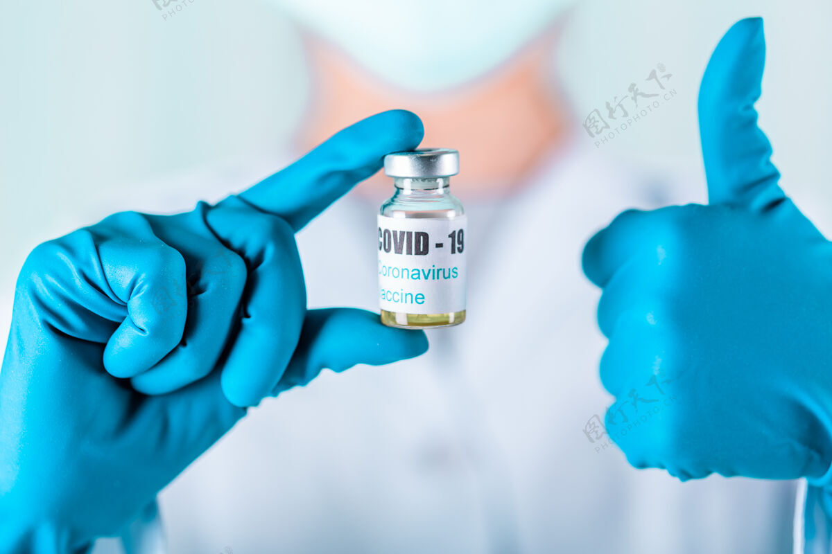 预防女医生或护士穿着制服 戴着手套 戴着口罩 在实验室里拿着带有冠状病毒疫苗标签的药瓶疫苗瓶疫苗实验室治疗