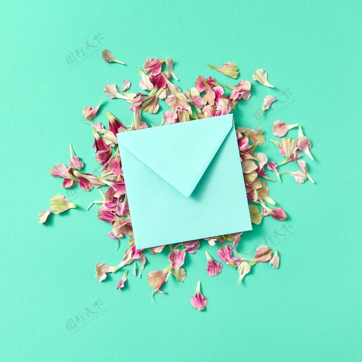 空白在绿松石色背景上的花瓣上用手工制作的信封和复印件制作的贺卡空间.平面躺着嘲笑-起来颜色妈妈信息