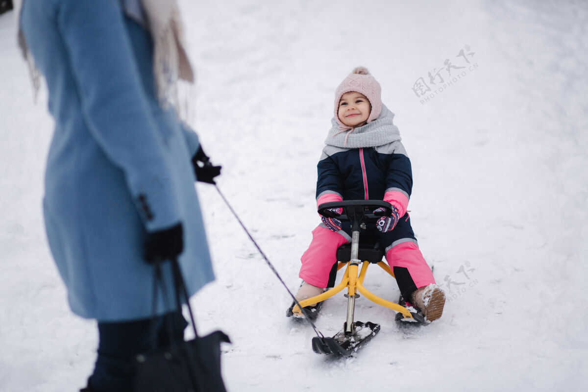 骑小女孩喜欢滑雪橇父母乐趣公园