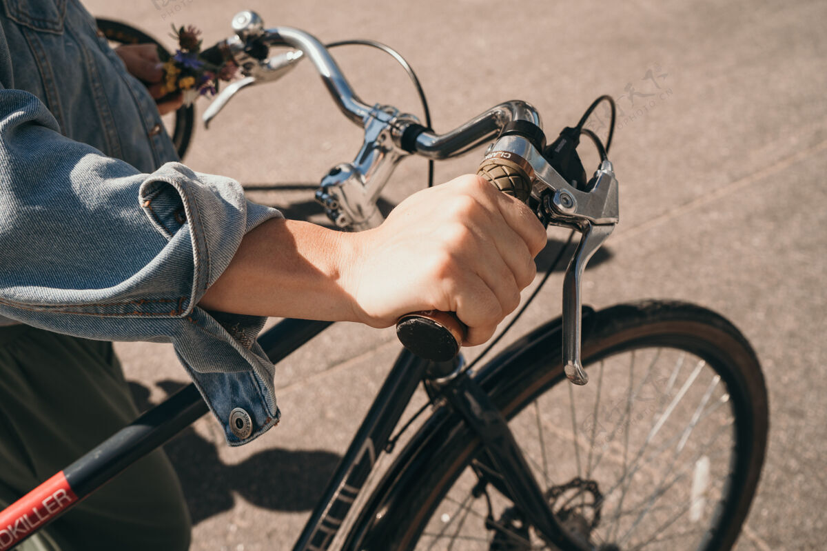 城市女孩握着自行车的轮子一个男人推着自行车户外把手科技