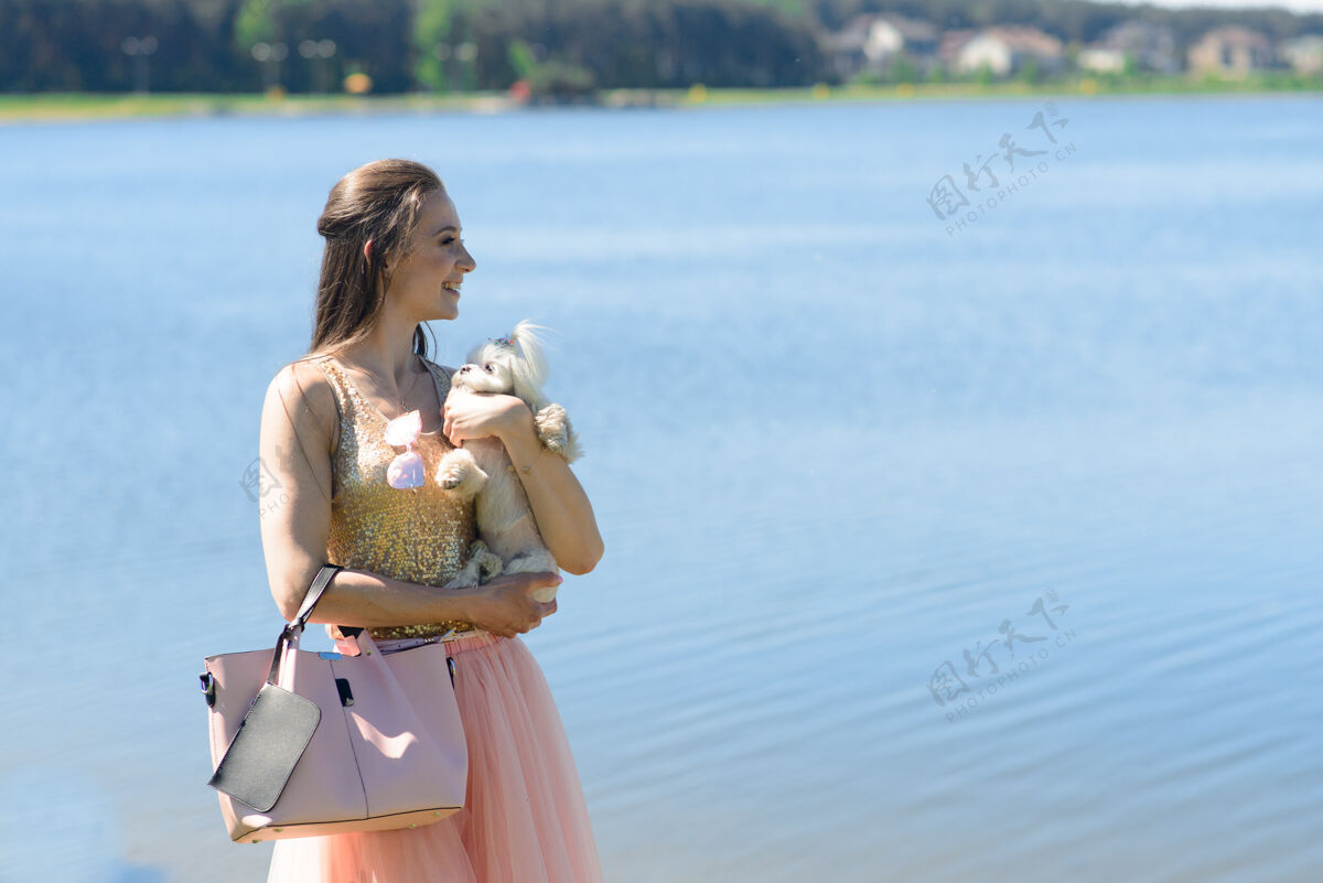 宠物年轻女人和她在一起狗小狗白狗正和它的狗一起跑业主概念关于友谊和动物能量小狗散步