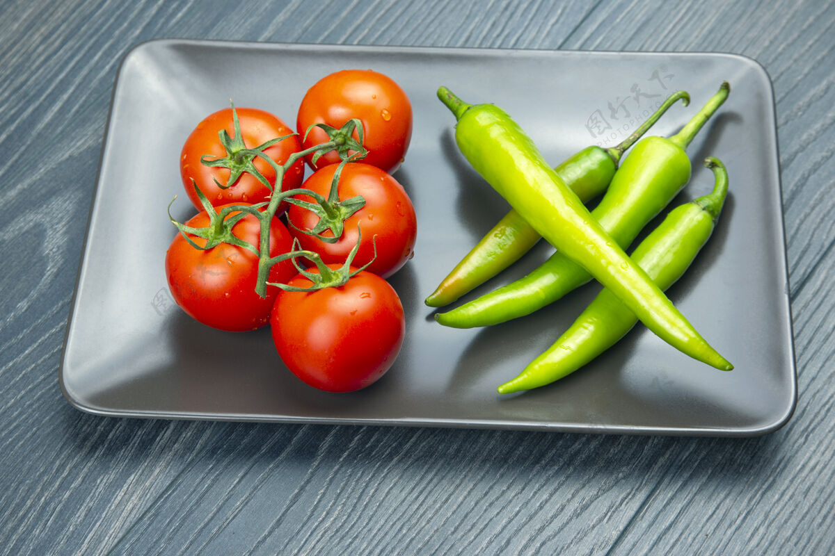 热红番茄和绿辣椒放在菜板上营养烹饪收获