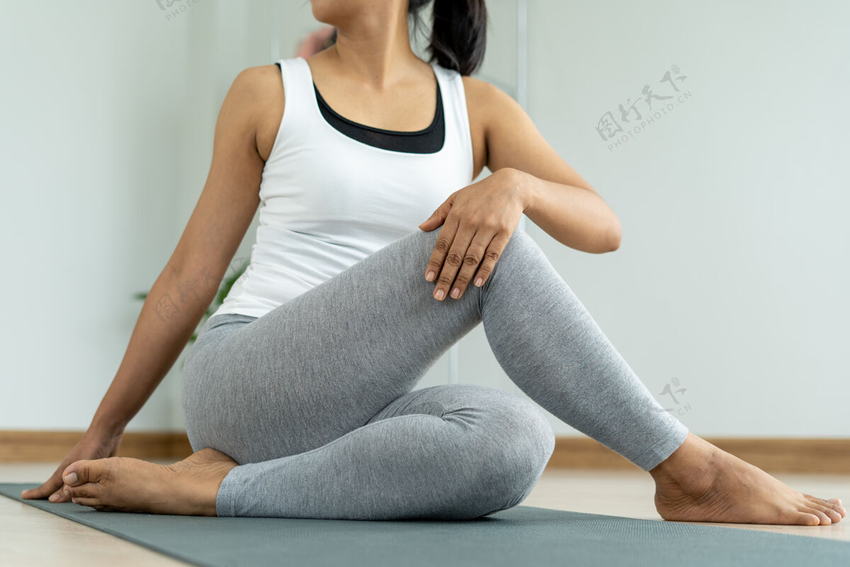 腿年轻女子在家里做伸展运动放松训练冥想瑜伽