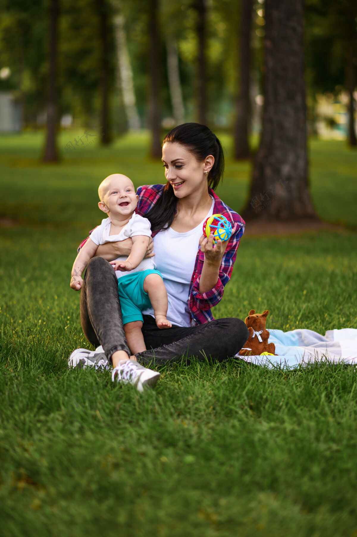 妈妈妈妈和她的小宝宝在夏日公园的草地上摆姿势父母女性孩子