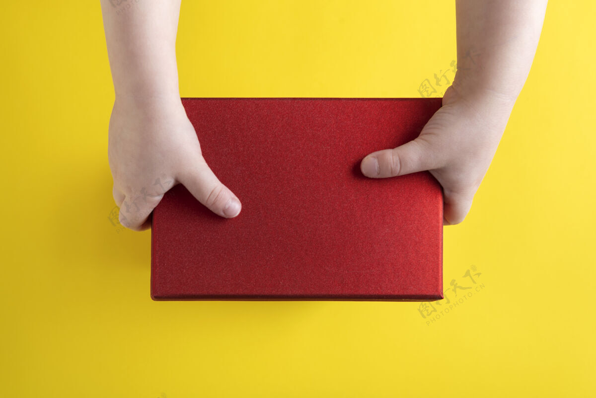 送货孩子们的手拿着黄色的红色纸板箱背景.top查看.复制空格.mock起来复印空间持有儿童