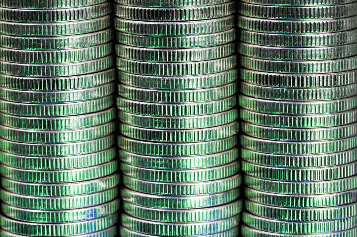价格许多银色的圆形金属硬币被绿色照亮支付财产铁