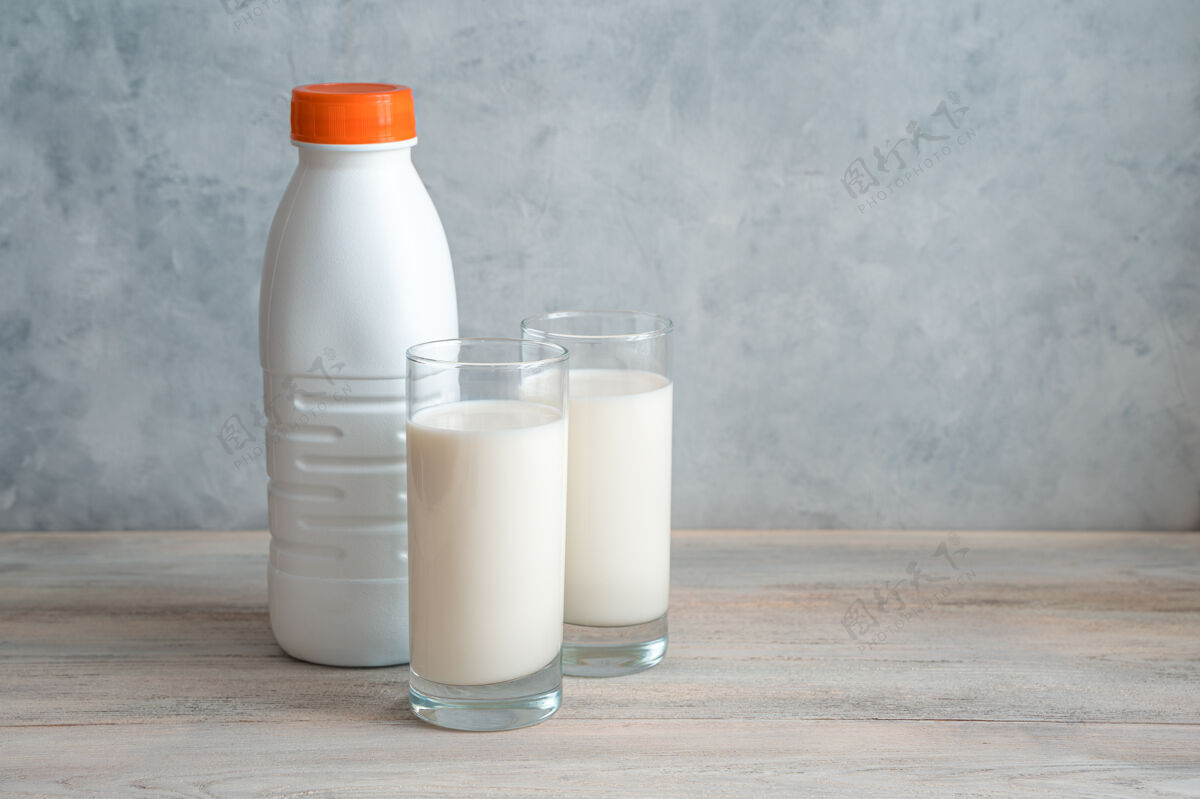 白色一瓶牛奶 两杯牛奶 背景是灰色的牛奶健康营养
