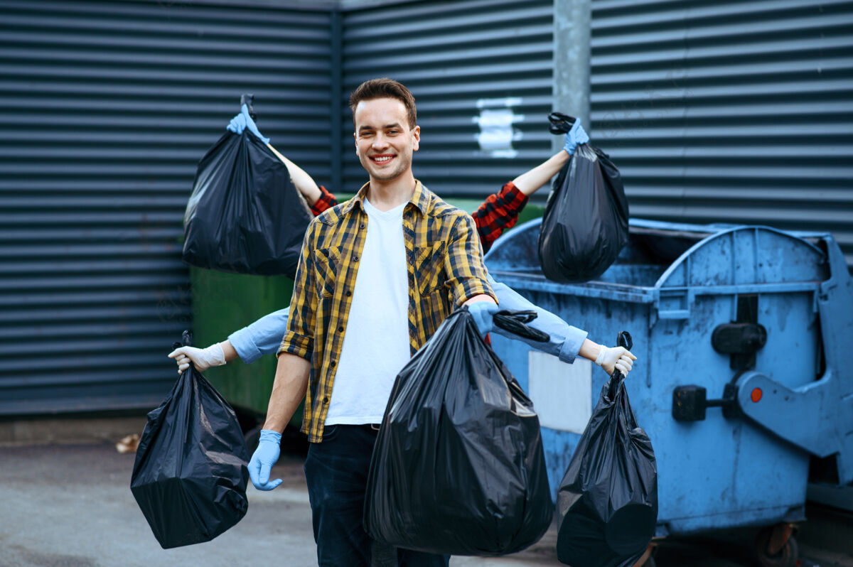 材料有趣的志愿者在户外展示塑料垃圾袋 志愿者人清洁城市街道 生态修复 垃圾回收 生态关怀 环境清洁自然垃圾箱护理
