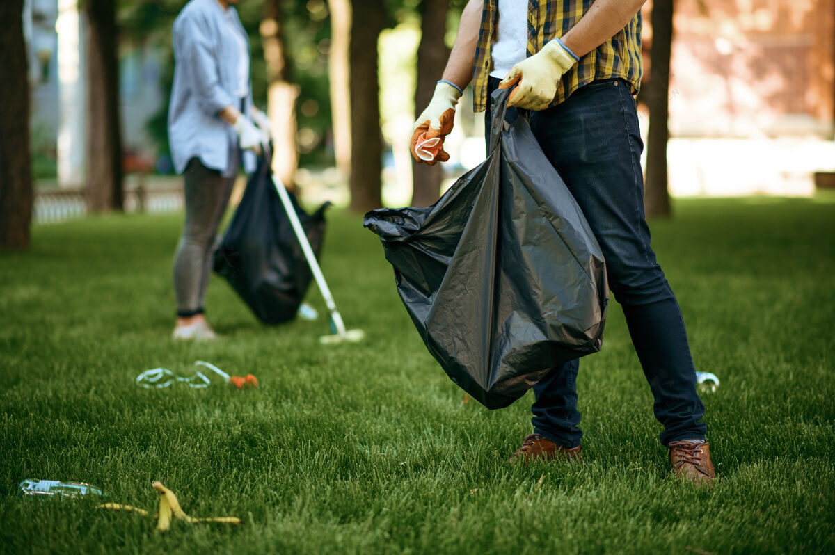 挑选人们在公园里用袋子收集垃圾 志愿服务男人清林 生态修复 生态生活方式 垃圾收集回收 生态关爱 环境清洁材料生态瓶子