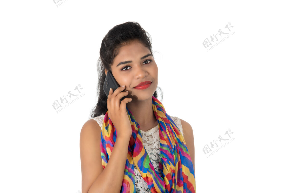 科技年轻的印度女孩用手机或智能手机隔离在白色电话女士成人